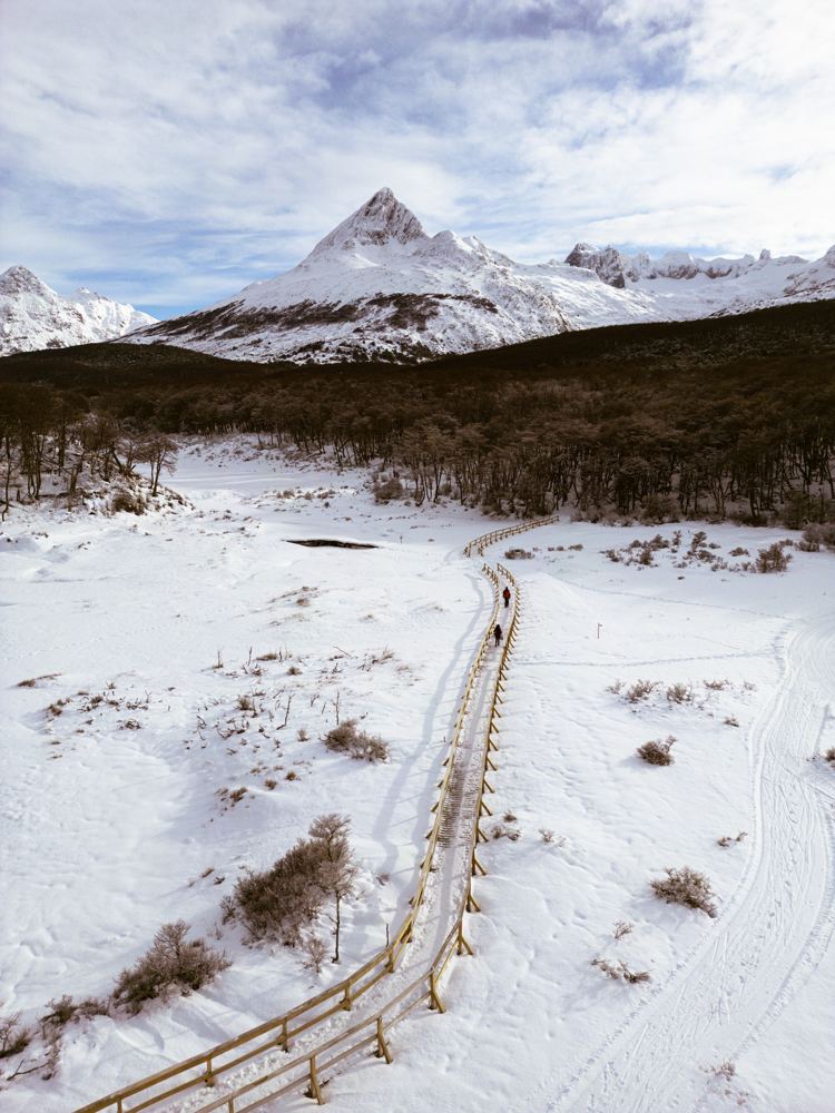 Pasarelas de madera de lenga sobre el turbal nevado en el valle, camino a Laguna Esmeralda